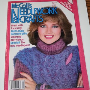 May include: A vintage McCall's Needlework & Crafts magazine from Jan/Feb 1981 featuring a cover with a person wearing a purple textured knit sweater with a high collar and a pink pin. The cover includes text about quilts, rugs, and needlepoint.