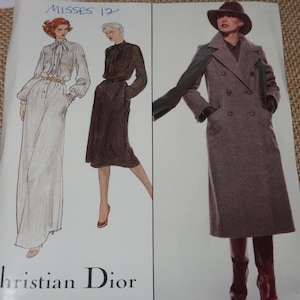 May include: A vintage fashion illustration from Christian Dior featuring three women's outfits. The illustration includes a long white dress, a dark brown dress, and a long brown coat with a hat. The text "Christian Dior" is at the bottom.