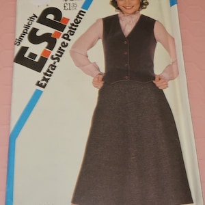 May include: Simplicity Extra-Sure Pattern 5656 for sizes 10, 12, and 14. The pattern includes instructions for a brown vest and skirt. The model is wearing a pink blouse, which is not included in the pattern.