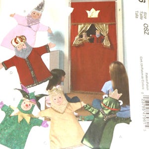 May include: A collection of handmade puppet designs, including a king, a jester, and a frog prince. The puppets are made of fabric and feature detailed facial expressions and costumes. A red puppet theater with a gold crown is also shown.