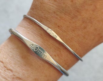 May include: Two silver-colored metal crochet hooks with a smooth, rounded design. The top hook is engraved with the text 2.0mm, and the bottom hook is engraved with the text 4.0mm. Both hooks feature a flattened, tapered section for grip.