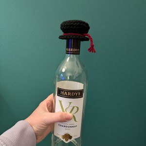 K&ouml;nnte beinhalten: Eine klare Glasflasche Hardy's Varietal Range Chardonnay Wein mit einem schwarzen H&auml;kelhut auf der Oberseite. Die Flasche hat ein wei&szlig;es Etikett mit dem Text "Hardy's Varietal Range Chardonnay 2023" und dem Text "Est'd 1832".