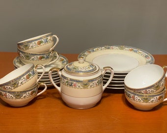 May include: A set of vintage teacups and saucers with floral patterns in shades of blue, green, and yellow. The set includes a teapot with a matching design.
