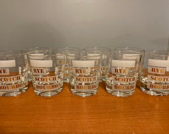 May include: Eight clear glass tumblers with gold lettering that reads "RYE SCOTCH BOURBON".
