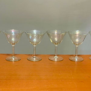 May include: Six clear iridescent glass cocktail glasses with a scalloped rim.
