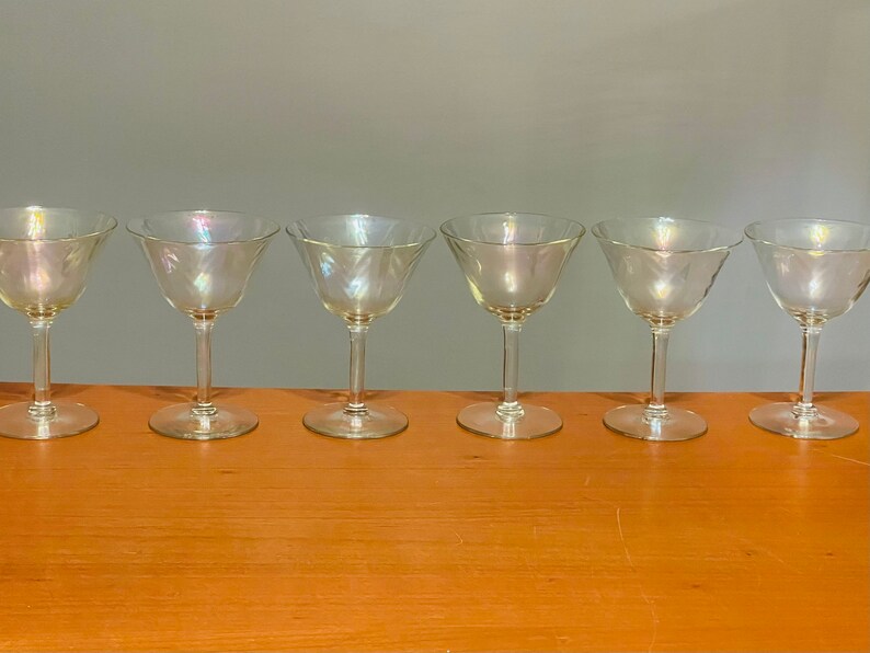 May include: Six clear iridescent glass cocktail glasses with a scalloped rim.