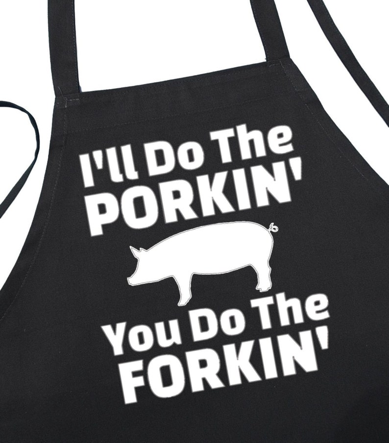 May include: Black apron with white text that reads "I'll Do The Porkin'" with a white silhouette of a pig and "You Do The Forkin'"