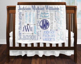 May include: White baby blanket with blue and gray text that reads "Jackson Michael Williams" with arrows and a monogram of "JWM".