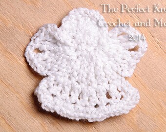 Puede incluir: Flor blanca de ganchillo con un hilo brillante. La flor está sobre una superficie de madera. El texto "The Perfect Knot Crochet and More 2014" está en la esquina superior derecha de la imagen.