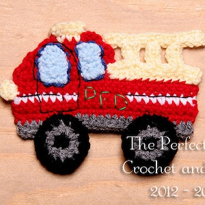May include: A crocheted red fire truck with a white ladder, blue windows, and gray wheels. The truck has the letters "FD" embroidered on the side.