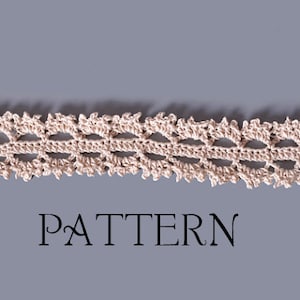May include: A delicate crocheted lace trim with a scalloped edge and a repeating pattern of oval shapes. The trim is beige and has silver metal clasps on each end. The word "PATTERN" is printed below the trim.