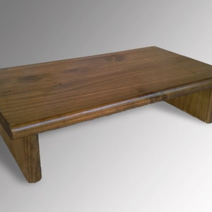 May include: A dark brown wooden riser with a rounded edge. The riser is made of solid wood and has a natural finish.