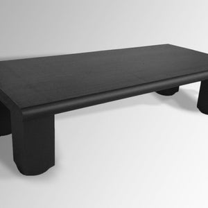May include: A black wooden coffee table with a rectangular top and four short, thick legs. The table has a slightly rounded edge on the top.