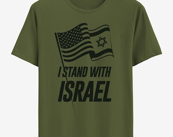 May include: Olive green t-shirt featuring a black graphic of the American and Israeli flags waving together. The text "I STAND WITH ISRAEL" is printed below the flags in a bold, sans-serif font. The shirt is displayed on a white hanger.
