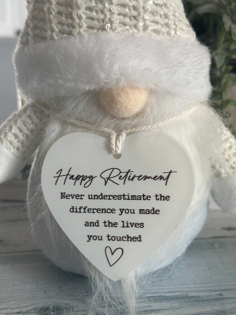 May include: White gnome figurine with a heart-shaped sign that reads "Happy Retirement. Never underestimate the difference you made and the lives you touched."