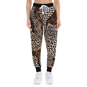 May include: Brown, white, and black patterned sweatpants with a black elastic waistband and drawstring. The sweatpants have a relaxed fit.
