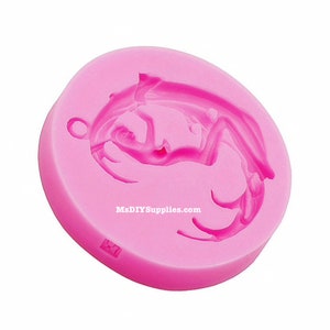 May include: A pink silicone mold with a dragon design. The mold is circular with a small hole for hanging. The dragon is detailed with curved lines and a textured surface. The text "MsDIYSupplies.com" is printed on the side.