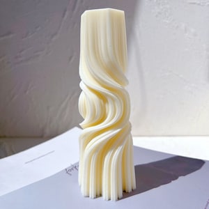 May include: A white, 3D printed sculpture with a swirling, wave-like design. The sculpture is tall and slender, with a smooth, matte finish.