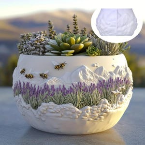 Könnte beinhalten: Weißer Keramik-Pflanztopf mit einer modellierten Landschaft aus Bergen, Lavendel und Bienen. Der Topf ist mit verschiedenen Sukkulenten und Pflanzen gefüllt. Das Design umfasst dreidimensionale Details und eine naturalistische Ästhetik.