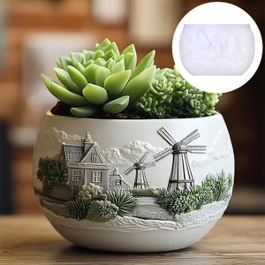 May include: White ceramic succulent planter featuring a raised design of a Dutch village with windmills and houses. The planter is filled with green succulents.