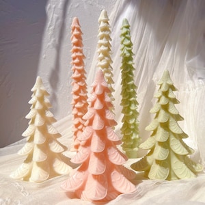 Puede incluir: Seis velas decorativas de árbol de Navidad en varios tonos de verde, blanco y rosa. Las velas están hechas de cera y tienen un diseño detallado y texturizado.
