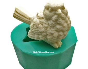 May include: A green silicone mold for making a small bird figurine. The mold is shaped like a bird with its wings spread out. The bird is sitting on a branch.