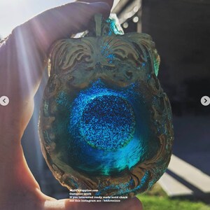 May include: A decorative, ornate resin piece with a blue and gold color scheme. The piece has a central blue, circular design with glitter, and the edges are gold. The text "MADIYSupplies.com" is visible.