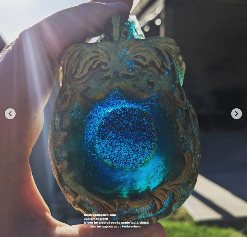 May include: A decorative, ornate resin piece with a blue and gold color scheme. The piece has a central blue, circular design with glitter, and the edges are gold. The text "MADIYSupplies.com" is visible.