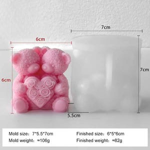 May include: A pink silicone mold for making a candle or soap, featuring two teddy bears embracing a heart with rose details. The mold is 7 cm tall and 7 cm wide. Next to it is a cylindrical mold.