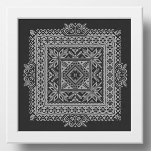 May include: A black and white framed cross-stitch pattern with a geometric design. The pattern is made up of squares and diamonds, and it is surrounded by a border of swirls.