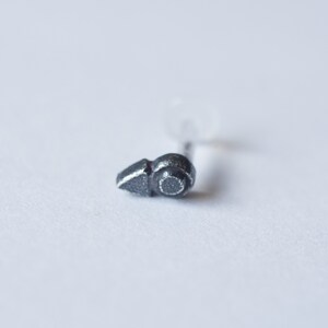 Puede incluir: Un peque&ntilde;o aro para la nariz de plata con un dise&ntilde;o geom&eacute;trico simple. El aro est&aacute; hecho de metal y tiene un acabado liso y pulido.