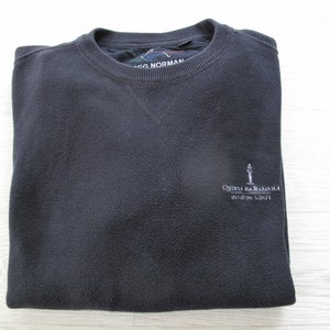 Könnte beinhalten: Ein dunkelgrauer Pullover mit einem weißen gestickten Logo, das "Quinta da Marinha - Oitavos Golf" lautet.