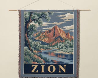 May include: A woven wall tapestry featuring a landscape illustration of Zion National Park with red rock mountains, a flowing river, and green trees. The word ZION is printed in large beige capital letters at the bottom of the design.