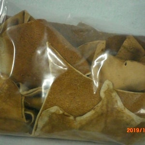 May include: A transparent plastic bag containing numerous light brown, irregularly shaped pieces. The pieces have a textured appearance, suggesting they are dried. The date "2019/11/20" is visible on the bag.