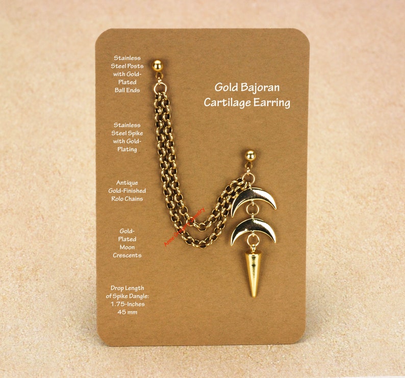 Peut inclure: Boucle d'oreille cartilage Gold Bajoran dor&eacute;e avec cha&icirc;ne, croissants de lune et pendentif en forme de pointe. L'accessoire est pr&eacute;sent&eacute; sur une carte marron. La longueur de la pointe est de 4,4 cm.
