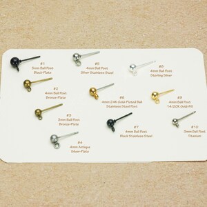 Peut inclure: Diverses tiges de boucles d'oreilles sont pr&eacute;sent&eacute;es sur une carte blanche. Les tiges varient en taille et en couleur, notamment noir, bronze, argent et or. Le texte sur la carte indique la taille et le mat&eacute;riau de chaque tige, comme "5mm Ball Post Black-Plate."