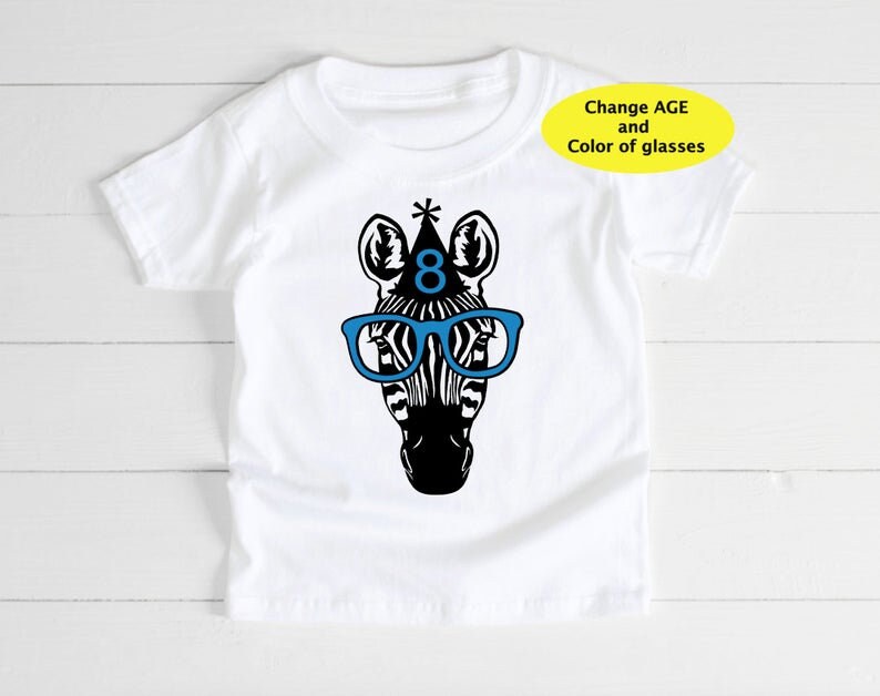 May include: White t-shirt featuring a black and white zebra head wearing blue glasses and a party hat with the number 8. The text "Change AGE and Color of glasses" is in a yellow oval.