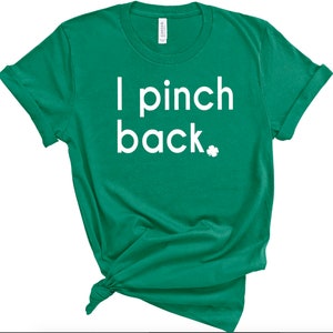 May include: Green t-shirt with the text "I pinch back" in white, along with a small white shamrock. The shirt is knotted at the bottom. The sleeves are rolled up.