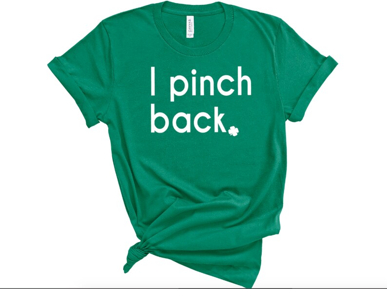 May include: Green t-shirt with the text "I pinch back" in white, along with a small white shamrock. The shirt is knotted at the bottom. The sleeves are rolled up.