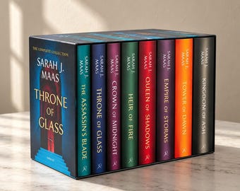 May include: A complete book collection box set by Sarah J. Maas titled Throne of Glass. The set includes eight books with spines in varying colors: teal, blue, purple, green, red, dark purple, orange, and black, all featuring gold text.