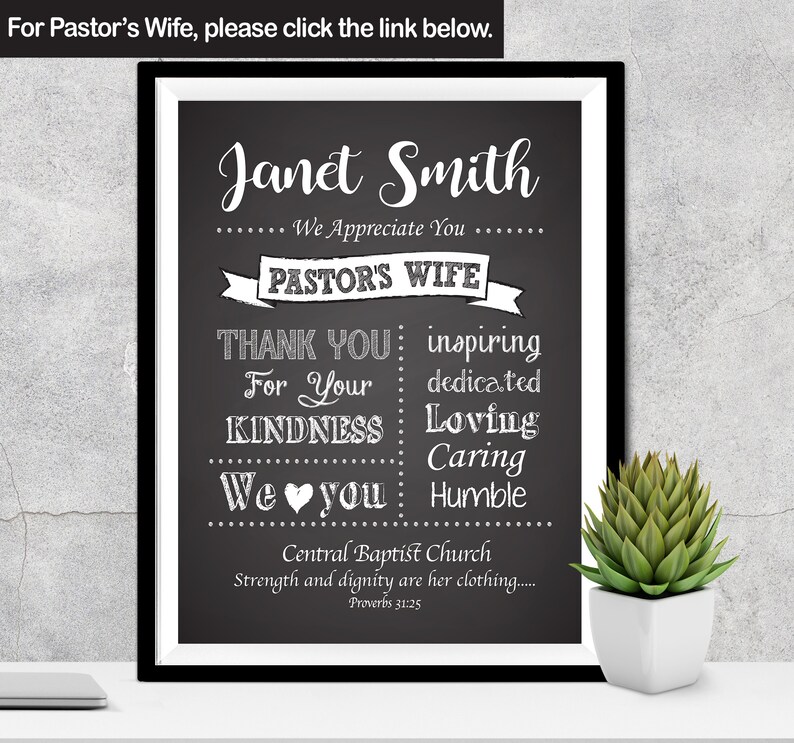 May include: Black and white chalkboard sign with the text "Janet Smith" and "Pastor's Wife". The sign also includes the text "Thank You" and "We Love You" with a heart symbol. The sign is framed in a black frame and is sitting on a table with a small potted plant.