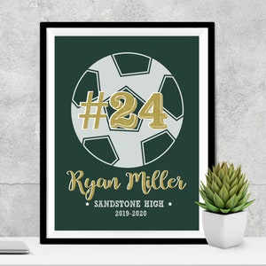 May include: A green and white soccer ball with the number 24 in gold glitter on it. The text "Ryan Miller" is below the ball, followed by "Sandstone High" and "2019-2020".