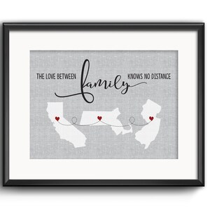 May include: A gray and white print with the text "The love between family knows no distance". The print features a map of the United States with three states highlighted and connected by a dotted line. Red hearts mark the locations of the states.