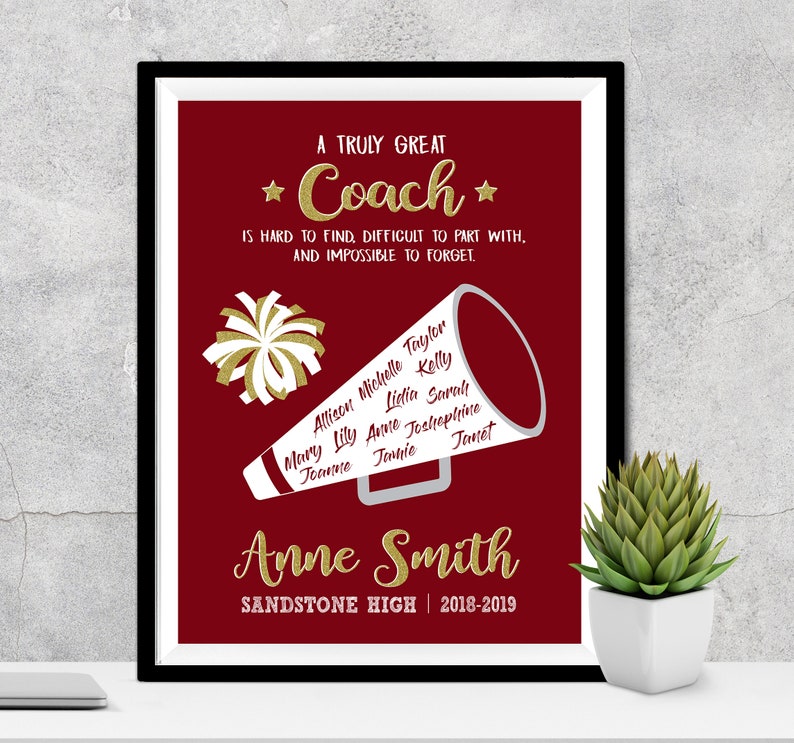 May include: A red and white framed print with a gold glitter design that says "A Truly Great Coach is hard to find, difficult to part with, and impossible to forget." The print also features a white megaphone with names written on it and a white pom-pom. The print also says "Anne Smith Sandstone High | 2018-2019".