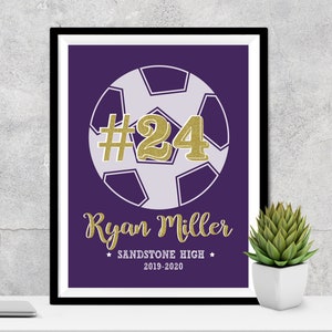 May include: Purple and white soccer ball with the number 24 in gold glitter on a purple background. The text "Ryan Miller" is below the ball in gold glitter. The text "Sandstone High" and "2019-2020" are below the name.