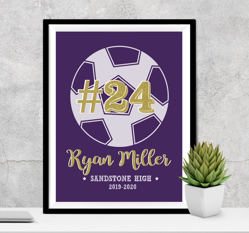 May include: Purple and white soccer ball with the number 24 in gold glitter on a purple background. The text "Ryan Miller" is below the ball in gold glitter. The text "Sandstone High" and "2019-2020" are below the name.