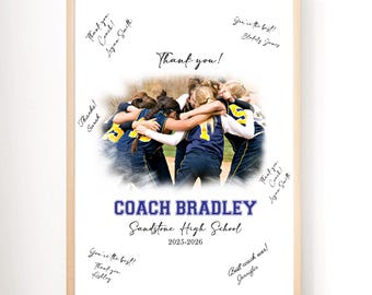 May include: Framed team photo with a light wood frame. The photo features a group of softball players in blue and yellow uniforms, embracing. Text includes "Thank you!" and "Coach Bradley, Sandstone High School, 2025-2026."