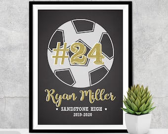 May include: Black and white soccer ball with a gold number 24 on it. The text "Ryan Miller" is below the ball, and the text "Sandstone High 2019-2020" is below that.