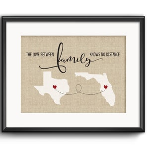 May include: A beige canvas print with the text "The love between family knows no distance" and outlines of Texas and Florida with red hearts on each state.