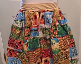 May include: A colorful apron with a patchwork design featuring images of doors, windows, and fruit. The apron has a tan waistband and two pockets. The fabric is a mix of red, blue, green, and tan.